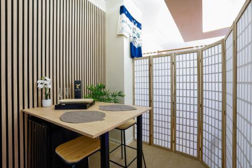 une pièce avec une table et deux tabourets dans l'établissement Zen Love Room Jaccuzzi Sauna, à Pontivy