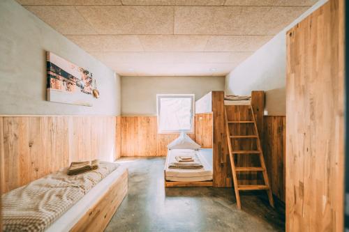 a room with a bunk bed and a ladder at Möttelin Gut Hügle in Ravensburg