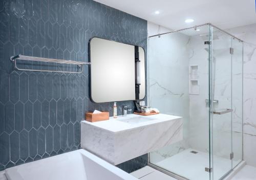 a bathroom with a sink and a mirror at Amanta Hotel & Residence Sathorn in Bangkok