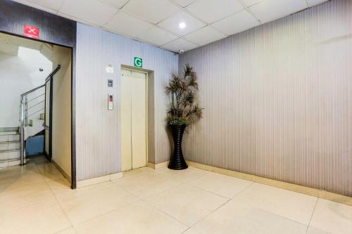 a hallway with a vase with a plant in it at Hotel O Model Town Road Near Bus Stand in Ludhiana