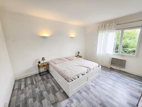 a white bedroom with a bed and a window at Le Cosy du Lac in Château-Arnoux-Saint-Auban