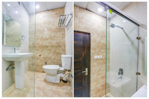a bathroom with a toilet and a glass shower at Hotel O Model Town Road Near Bus Stand in Ludhiana