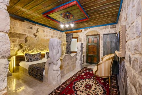 a bedroom with a bed in a room with a stone wall at Kayatas Cave Suites in Goreme