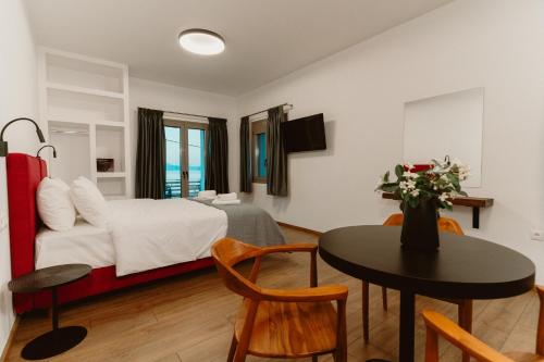a hotel room with a bed and a table and a tableablish at Ollenia's Harmony Luxury Apartments in Derveni