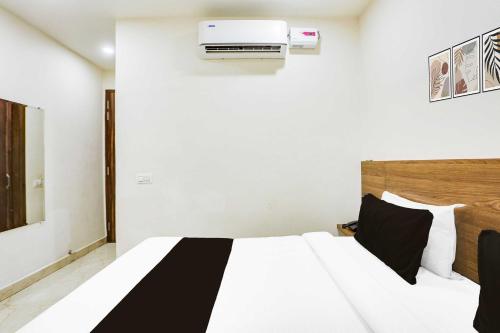 a bedroom with a bed with a air conditioner on the wall at Hotel O Clock Tower Ludhiana in Ludhiana