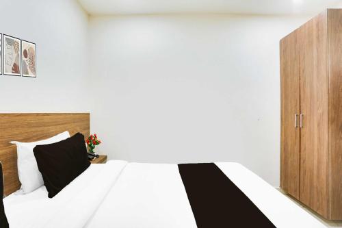a bedroom with a bed and a wooden cabinet at Hotel O Clock Tower Ludhiana in Ludhiana
