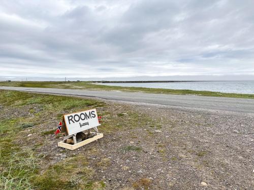 a road sign sitting on the side of a road at Svartbakken Rooms in Vardø