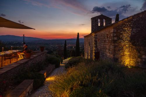a person sitting at a table on a patio at sunset at Tenuta San Pietro a pettine in Santa Maria in Valle