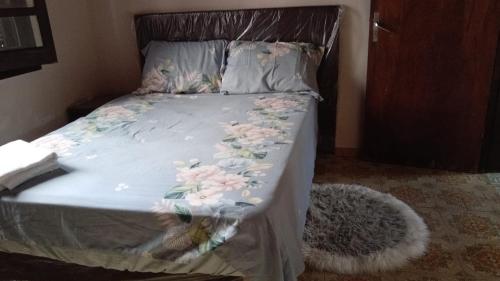 a bed with a blue comforter with flowers on it at Lapacho Roga in Asuncion