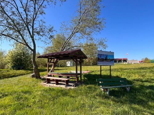 a picnic table and a shelter in a park at San Sebastian - domki nad morzem in Ustka