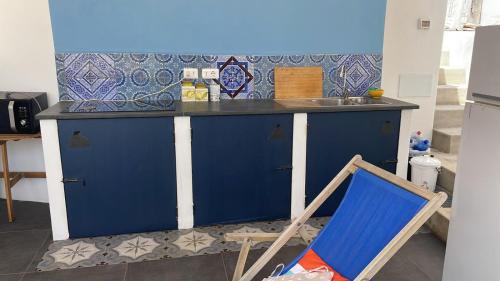 a blue kitchen with a blue counter and a chair at Casa Lilian in Stromboli