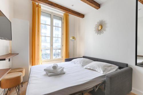 une chambre avec un lit et une fenêtre dans l'établissement Nazareth Sentier II Charming 4P Apartment, à Paris