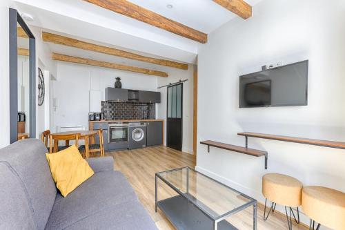 un salon avec un canapé et une télévision dans l'établissement Nazareth Sentier II Charming 4P Apartment, à Paris