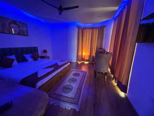 a blue room with two beds and a table at Adu's Eternal Comfort in Leh