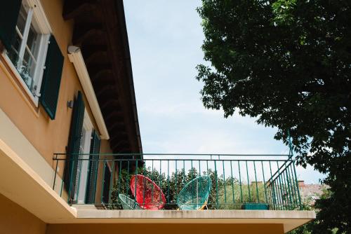three colorful chairs on a balcony of a building at Golden Flat by GrazRentals with parkview - brandnew & free parking in Graz