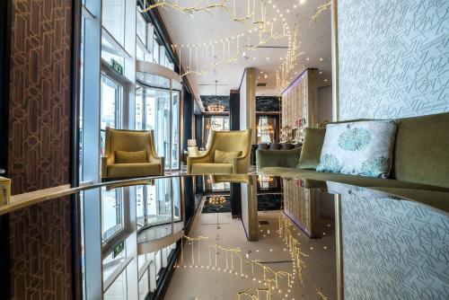 a lobby with chairs and lights on the wall at David Tower Hotel Netanya by Prima Hotels - 16 years Plus in Netanya