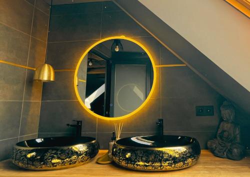 a bathroom with two sinks and a mirror at Greyhouse Apartments in Harkány