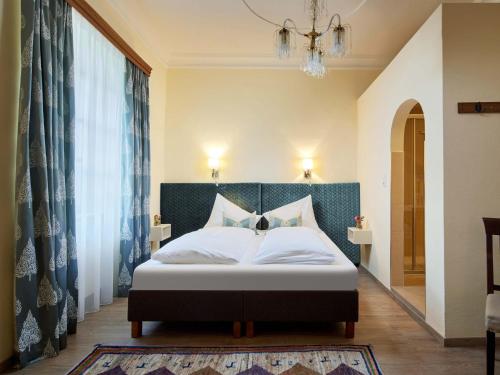 a bedroom with a bed and a chandelier at Schlosshotel Mitterhart in Schwaz