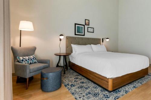 a hotel room with a bed and a chair at Four Points by Sheraton Myrtle Beach in Myrtle Beach