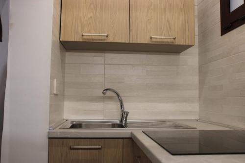 a kitchen with a sink and wooden cabinets at CRISTALLI Home in Galatina