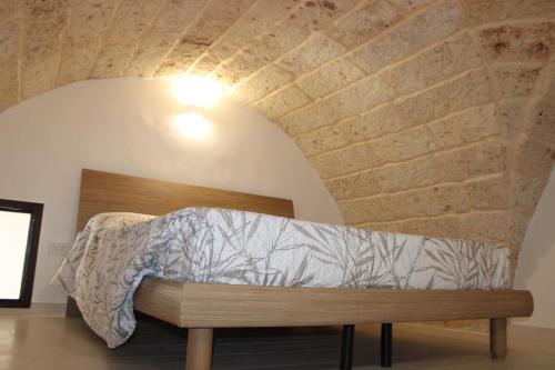 a bed in a room with a brick wall at CRISTALLI Home in Galatina