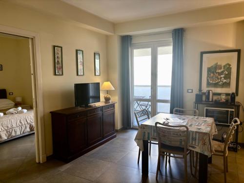 a living room with a dining room table and a television at Appartamento Attico - Penthouse - Palazzo San Matteo in Palermo