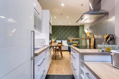 une cuisine avec des placards blancs et une salle à manger dans l'établissement Childebert - Furnished apartment - Downtown Lyon, à Lyon