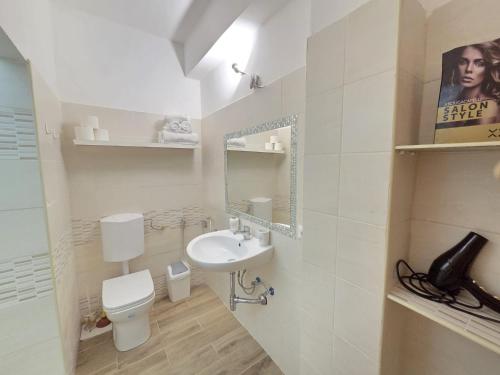 a bathroom with a sink and a toilet and a mirror at Bellavista Monolocale in Foligno