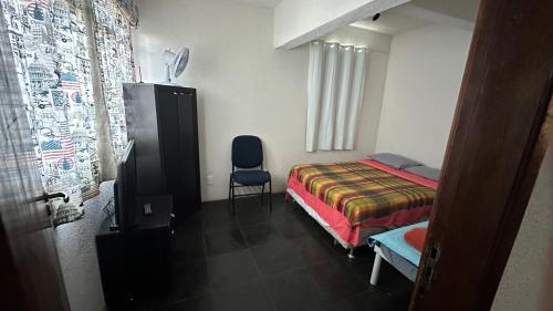 a bedroom with a bed and a chair in it at Apartamentos na região Central Cobertura e 2 quartos in Ponta Grossa