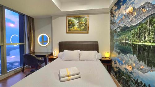 a hotel room with a bed and a painting on the wall at Sea View with Bridge at Gold Coast PIK high floor in Jakarta
