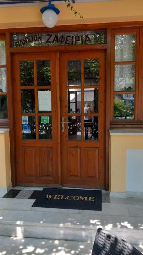 a door to a restaurant with a sign on it at Apartments Zafiria in Ágios Konstantínos
