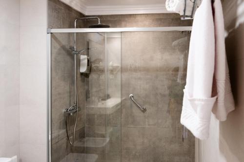 a shower with a glass door in a bathroom at Hotel Puerta del Mar - Adults Recommended in Nerja