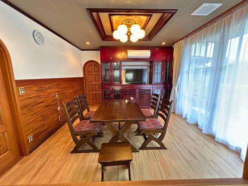a dining room with a wooden table and chairs at 鳴門市の貸切一軒家最大10名無料駐車場5台 in Naruto