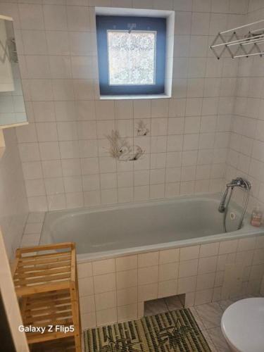 a bathroom with a tub and a toilet and a window at Privát Marika in Terchová