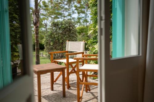 a porch with two chairs and a table and a door at Tenuta Centoporte in Otranto