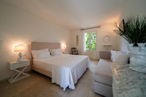 una camera da letto con un letto bianco e un divano di Tenuta Centoporte a Otranto