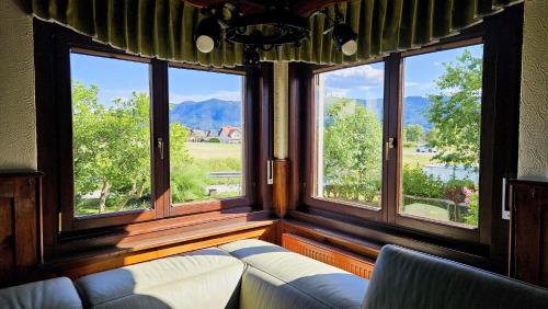 un soggiorno con divano e 3 finestre di Vila Moka near Bled-Entire place with Garden Retreat a Lesce