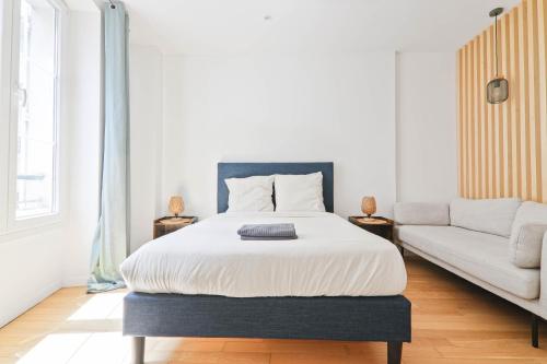 une chambre avec un lit et un canapé dans l'établissement 1 Bedroom Apartment - 6P - Republique, Paris, à Paris