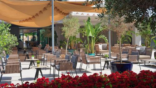 an outdoor patio with tables and chairs and flowers at H10 Casa del Mar in Santa Ponsa