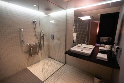 a bathroom with a sink and a glass shower at Logis Hotel L'Embarcadère in Nantua