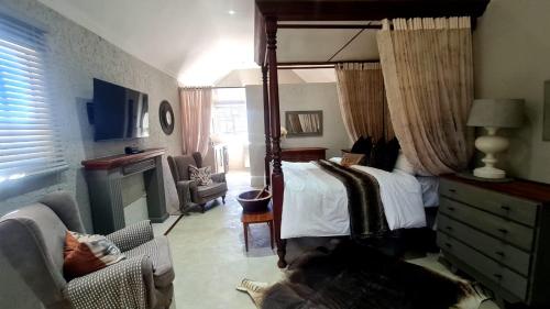 a bedroom with a canopy bed and a couch at Lala Panzi in Ghanzi