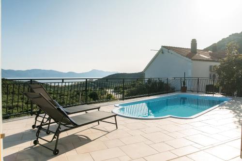 a patio with a chair and a swimming pool at BACINELLA apartmani in Baćina