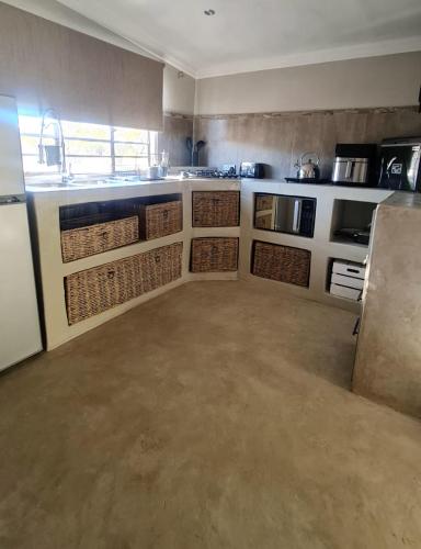 una cucina con cestini di vimini sui banconi e un lavandino di Lala Panzi a Ghanzi