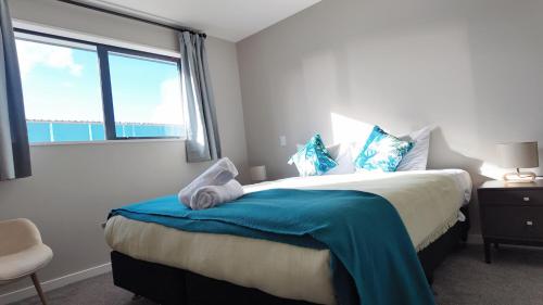 a bedroom with a large bed with a blue blanket at Tekapo Aunt Susan Holiday House in Lake Tekapo