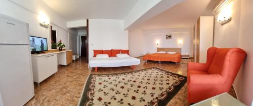 a living room with a bed and a couch and a tv at Hotel Lido in Mamaia