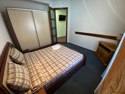 a small bedroom with a bed and a cabinet at Tourist Home at Stefan cel Mare with 2 rooms in Chişinău