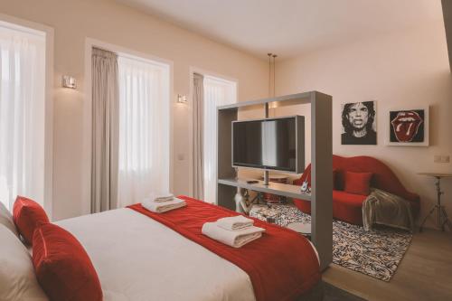a bedroom with a large bed and a flat screen tv at Viterbo'8 - Bonjardim Apartments in Porto
