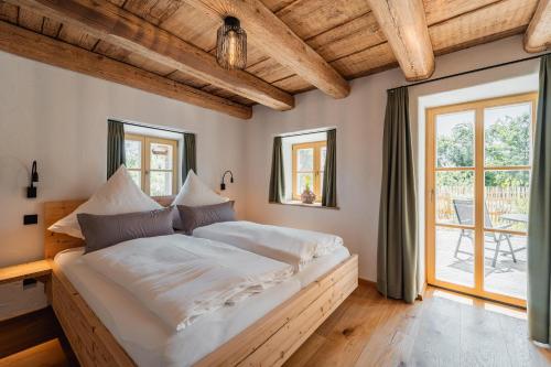 a bedroom with a large bed with white sheets at Heimelei in Ettendorf
