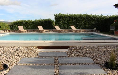 a swimming pool with chairs in a yard at Family Dream Dalmatia - Split by Villas Guide in Košute