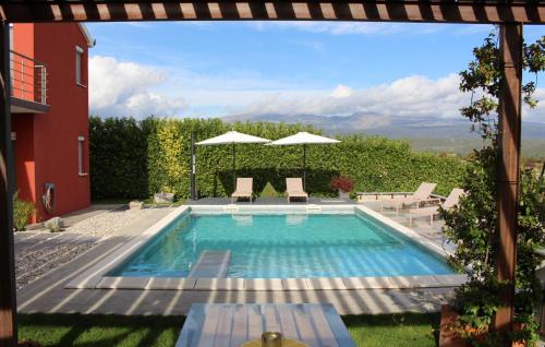 a swimming pool with chairs and umbrellas in a yard at Family Dream Dalmatia - Split by Villas Guide in Košute